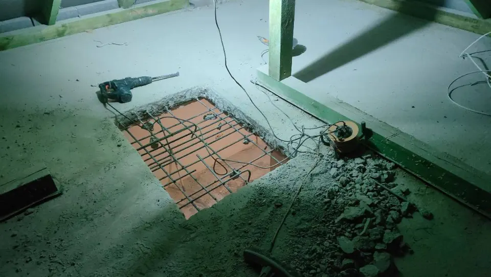 Demontaż posadzki betonowej — młot udarowy i gruz na wykopie