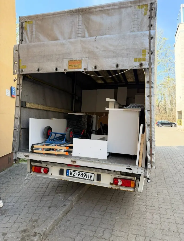 Załadunek mebli w tylnej części busa przeprowadzkowego