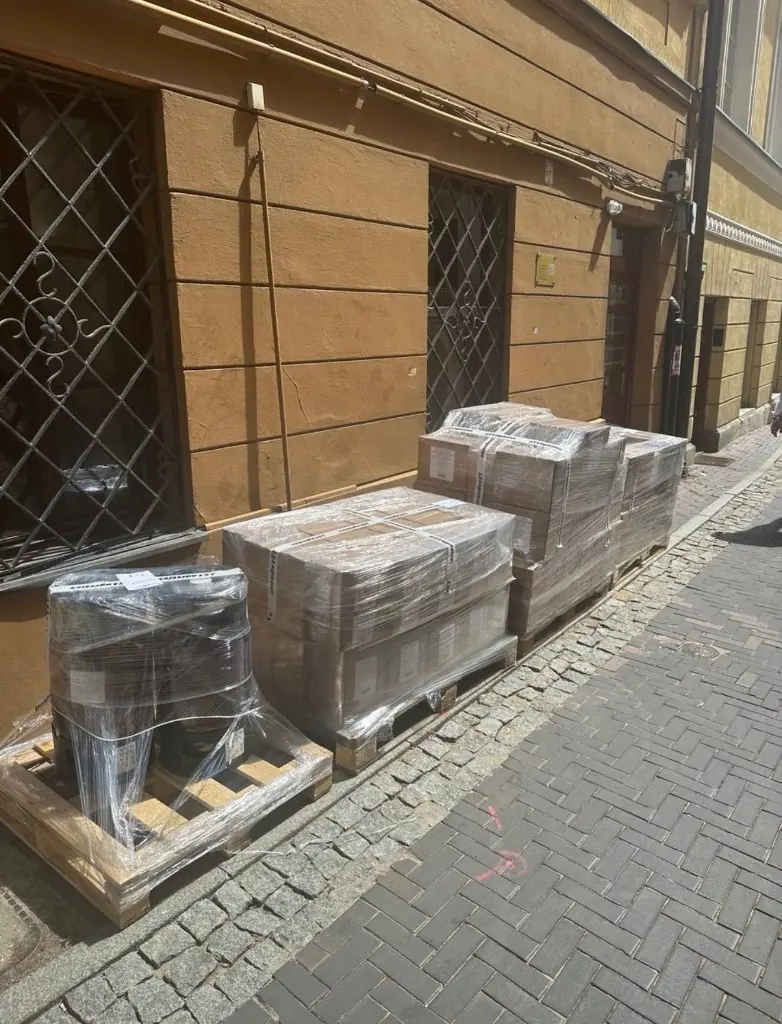 Palety z owiniętymi kartonami na chodniku przed załadunkiem